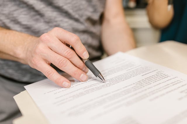 a hand pointing on document with a pen
